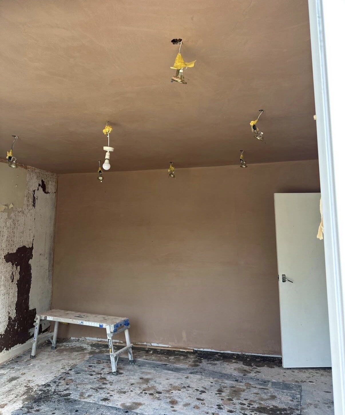 Newly plastered ceiling and walls with light fittings protected