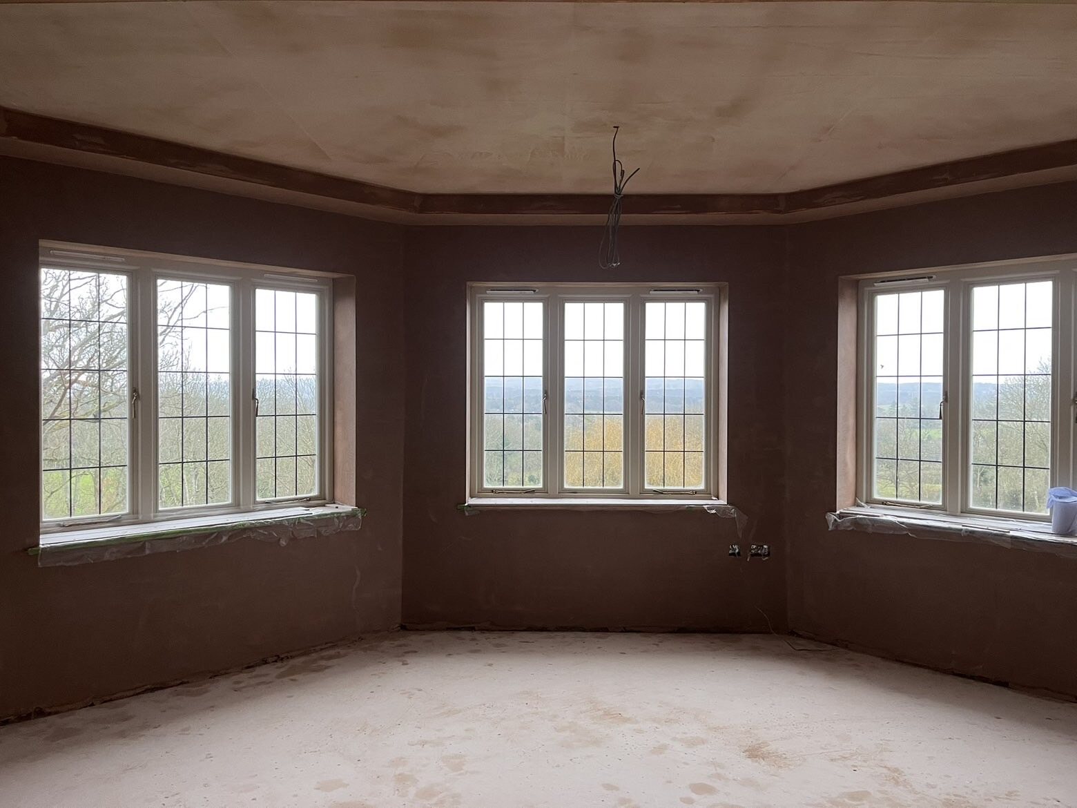 Plastered room with three bay windows and detailed ceiling edges